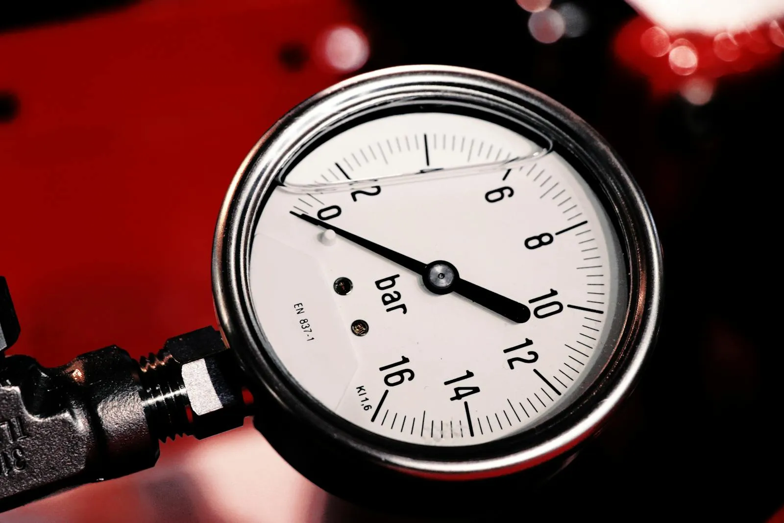 Close-up of a white-faced pressure gauge in bar
