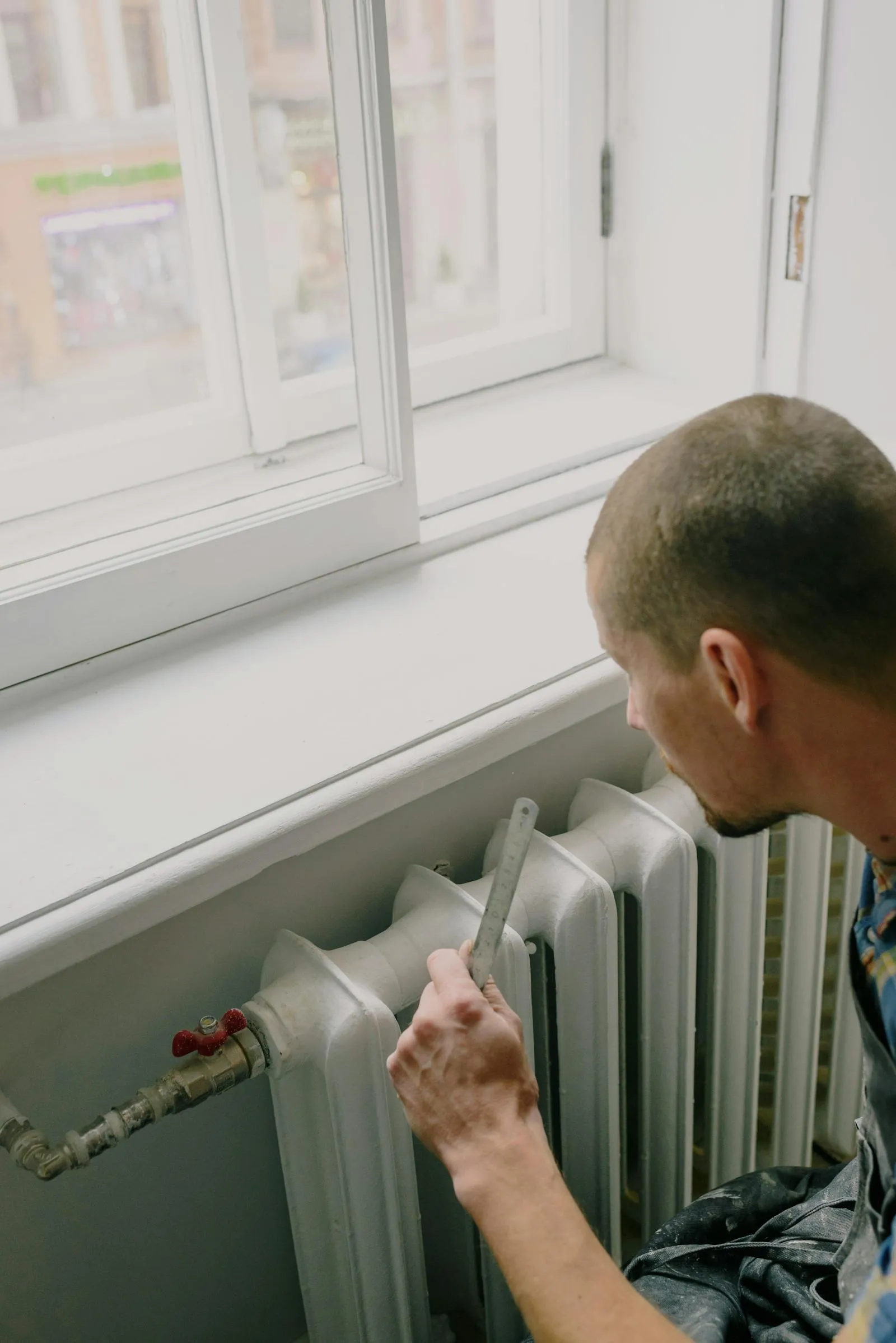 Engineer servicing a boiler with controls open